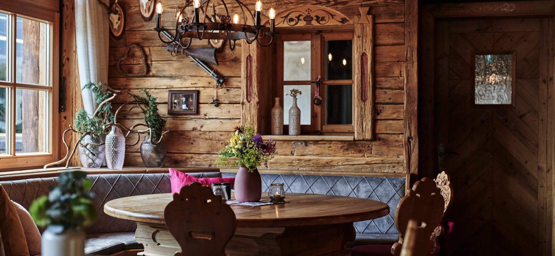 Gemütliche Stube im Gasthof Berglift mit Holzdekor und blühenden Pflanzen.